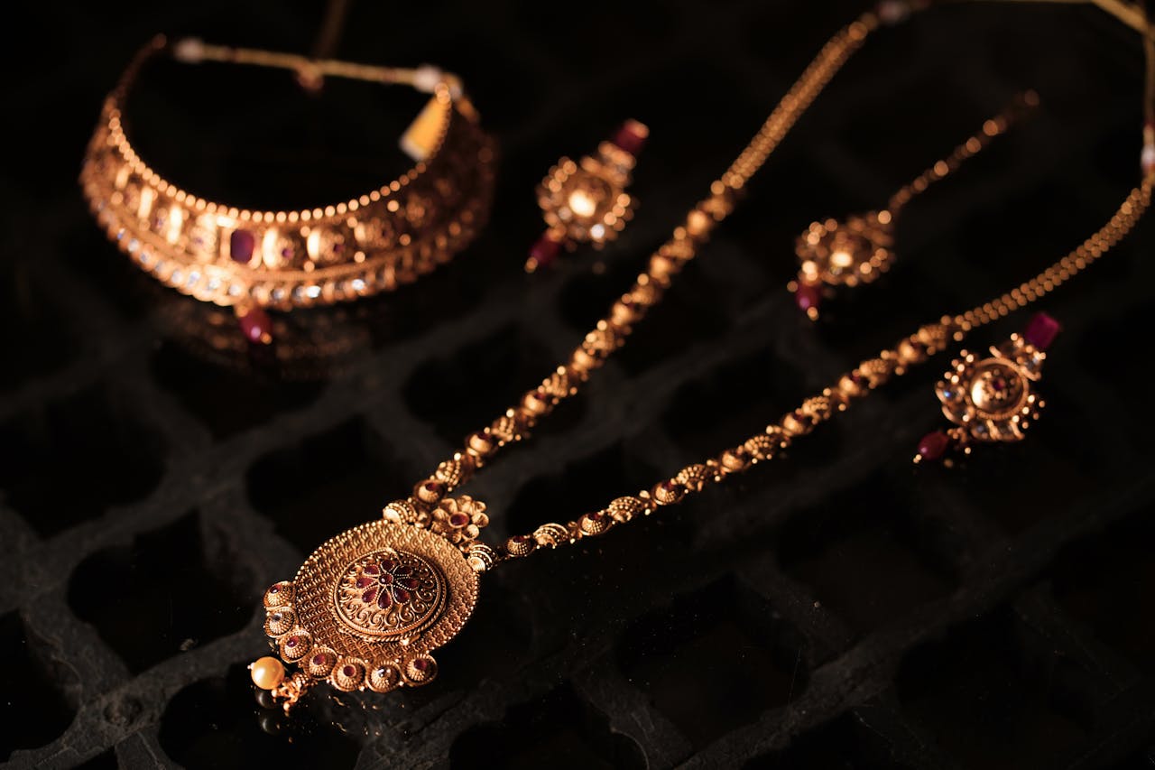 Close-up of a luxurious gold jewelry set featuring an opulent necklace and matching earrings.
